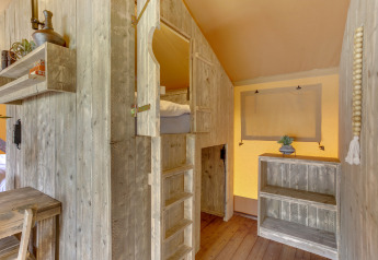 Interieur van safaritent in Dune Lodge bij Sandberghe, Nederland, met houten meubels en bedden.