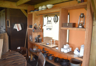 Rustikale Küche mit Holzmöbeln, Geschirr, Töpfen und Laterne im Beach Lodge Luxury, Duynpark Het Zwanenwater, Niederlande.