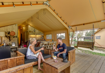 A couple enjoying wine in the spacious Forest Lodge safari tent at Sandberghe, Netherlands.