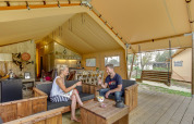 Una pareja disfruta de vino en la amplia tienda safari Forest Lodge en Sandberghe, Países Bajos.