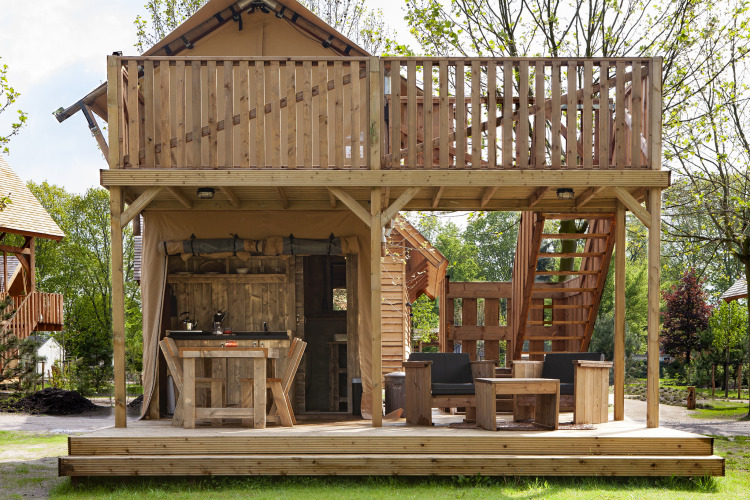 Tienda safari Forest Lodge Junior en Sandberghe, Países Bajos, con terraza de madera y zona de descanso.