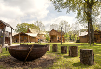 Forest Lodge Junior safari tent at Sandberghe in the Netherlands with fire pit and log seating outside.