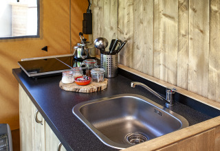Cucinotto nella tenda safari Forest Lodge Junior a Sandberghe, Paesi Bassi, con lavello e fornello elettrico.