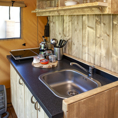 Kleine keuken in de Forest Lodge Junior safaritent bij Sandberghe, Nederland, met wasbak en kookplaat.