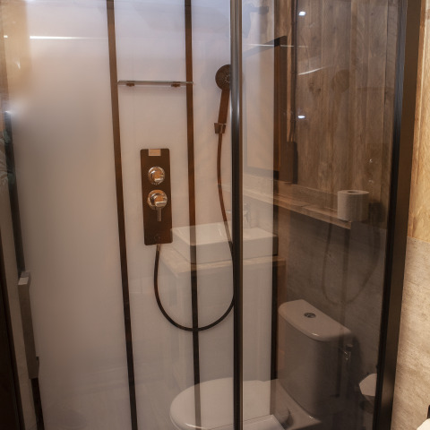 Badkamer met douche en toilet in een Forest Lodge Junior safaritent bij Sandberghe in Nederland.