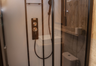 Badezimmer mit Dusche und Toilette im Forest Lodge Junior Safarizelt bei Sandberghe in den Niederlanden.