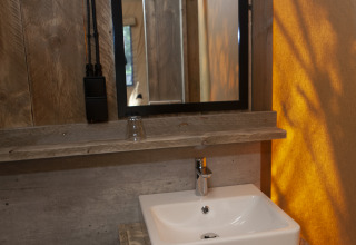 Lavabo y espejo del baño en la tienda safari Forest Lodge Junior de Sandberghe, Países Bajos.