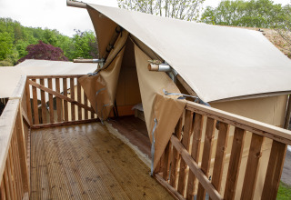 Houten terras met reling voor de ingang van een safaritent bij Forest Lodge Junior, Sandberghe.