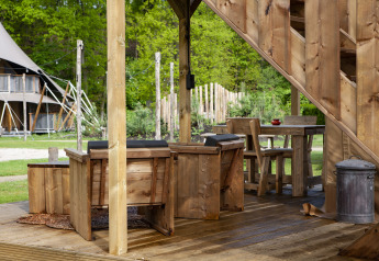 Houten terras met rustieke zitplaatsen aan safaritent, Forest Lodge Junior, Sandberghe, Nederland.