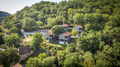 Vista aérea del lodge Chalet Belvedere en La Draille, Francia, rodeado de colinas y bosque verde.