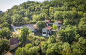 Vista aérea del lodge Chalet Belvedere en La Draille, Francia, rodeado de colinas y bosque verde.