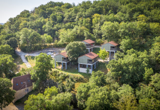 Vista aérea del lodge Chalet Belvedere en La Draille, Francia, rodeado de colinas y bosque verde.