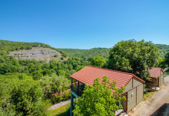 Vista sul Chalet Belvedere a La Draille in Francia, circondato da colline verdi e tetti rossi.