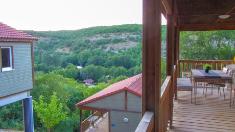 Vista desde la terraza del Chalet Belvedere en La Draille, Francia, con colinas y cabañas verdes.