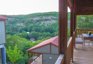 Vista desde la terraza del Chalet Belvedere en La Draille, Francia, con colinas y cabañas verdes.