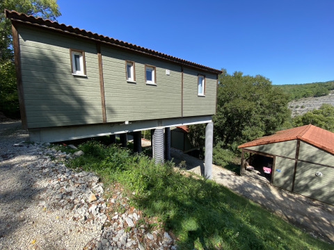 Udsigt over Chalet Belvedere på La Draille i Frankrig, et forhøjet træhus omgivet af natur og grønne træer.