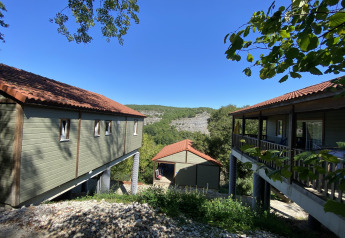 Chalet Belvedere lodge bij La Draille in Frankrijk met uitzicht op groene heuvels en blauwe lucht.