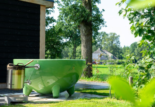 Grøn udendørs badekar og wellness ved hytte i Panorama lodge på Vakantiepark Hölte i Holland.