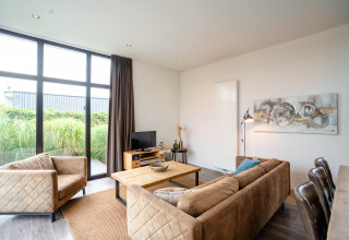 Helles Wohnzimmer in Cube Exclusif 4, Schoneveld, Niederlande, mit modernen Möbeln und großen Fenstern.