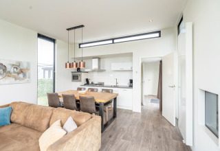 Cocina y comedor modernos y luminosos en la lodge Cube Exclusif 4 en Schoneveld, Países Bajos, con sofá.