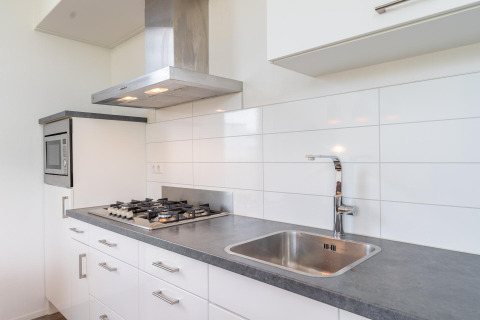 Cocina moderna en Cube Exclusif 4 con estufa a gas, extractor y fregadero en Schoneveld, Países Bajos.