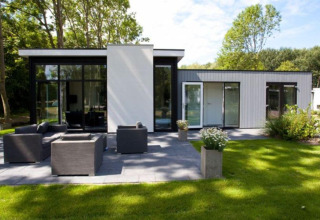 Cube Exclusif 4 lodge à Schoneveld, Pays-Bas, construction moderne, terrasse spacieuse et mobilier de jardin.