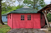 Foto de Writers hut, una pequeña casa roja de madera con techo verde en Zomerlicht, Países Bajos.