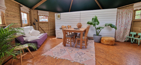 Knus interieur van het Writers hut in Zomerlicht, Nederland, met houten meubels en veel planten.