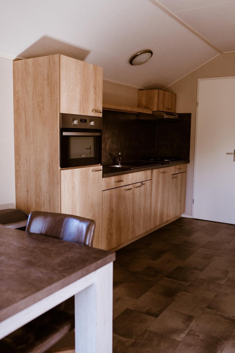 Modern kitchen design in Chalet lodge at Holiday park Eigen Wijze in the Netherlands with wood finish.