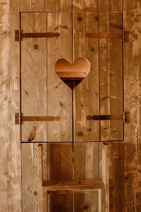 Puerta de madera con recorte en forma de corazón en tienda glamping en Holiday park Eigen Wijze, Países Bajos.
