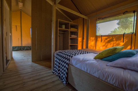 Vista interna di una camera da letto in tenda safari di lusso all'Holiday Park De Boshoek nei Paesi Bassi.
