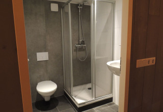Modernes Badezimmer im Luxus-Safarizelt mit Dusche, Toilette und Waschbecken im Holiday Park De Boshoek.