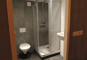 Modernes Badezimmer im Luxus-Safarizelt mit Dusche, Toilette und Waschbecken im Holiday Park De Boshoek.