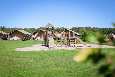 Tiendas safari de lujo y parque infantil en Holiday park De Boshoek, Países Bajos, en un día soleado.