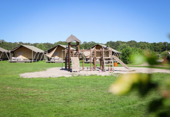 Tiendas safari de lujo y parque infantil en Holiday park De Boshoek, Países Bajos, en un día soleado.