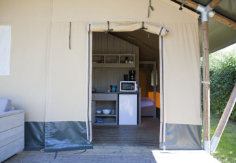 Innenraum eines Safari-Zeltes im Holiday Park De Boshoek, Niederlande, mit Küchenzeile und Bett.