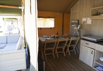 Intérieur de la tente Safari Tent au Holiday park De Boshoek aux Pays-Bas avec coin repas et terrasse