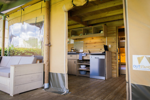 Innenansicht eines Luxus-Safari-Lodge-Zeltes mit Küche und Sofa im Holiday Park De Boshoek, Niederlande.