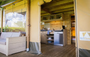 Vista interna di una tenda safari lodge di lusso a Holiday park De Boshoek, Paesi Bassi, con cucina e divano.