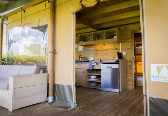 Binnenaanzicht van luxe safarilodge tent bij Holiday park De Boshoek in Nederland, met keuken en zithoek.