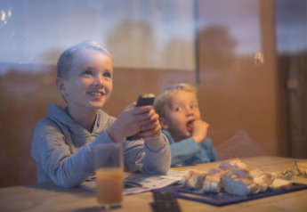 Deux enfants dégustent des snacks et du jus dans une tente safari de luxe au parc De Boshoek, Pays-Bas.