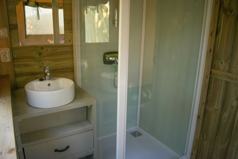 Baño de una lujosa Safari lodge en Holiday park De Boshoek, Países Bajos, con ducha, lavabo y espejo.