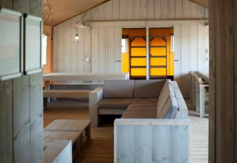 Interior de una villa de tienda safari con mobiliario de madera en Holiday park De Boshoek, Países Bajos.