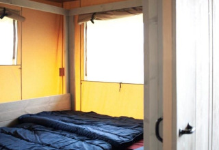 Indvendig udsigt over en safari-teltvilla ved Holiday park De Boshoek, Nederlandene, med to senge.