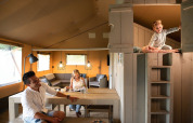 Familie hygger sig i et safarihus telt på Holiday park De Boshoek i Holland, barn leger i hems.