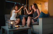 Drie vrouwen proosten met wijn op een gezellige veranda bij Safari House, De Boshoek, Nederland.