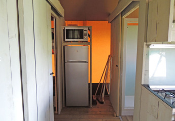Piccola zona cucina con frigorifero e microonde nella tenda Safari House del parco De Boshoek nei Paesi Bassi.