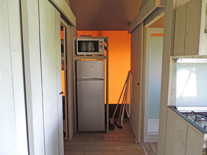 Kleine keuken met koelkast en magnetron in de Safari House tent op Vakantiepark De Boshoek in Nederland.