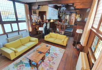 Sala de estar en la casa flotante De Zwerver en Marina Parcs Naarden, Países Bajos, con sofás amarillos y madera.