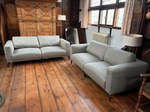 Dos sofás grises en la sala de Houseboat De Zwerver en Marina Parcs Naarden, Países Bajos.